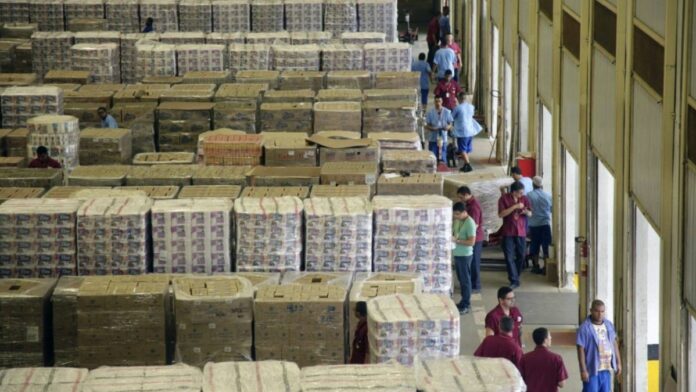 Carregador organizando mercadorias em um depósito do Supermercados Guanabara. vaga de carregador