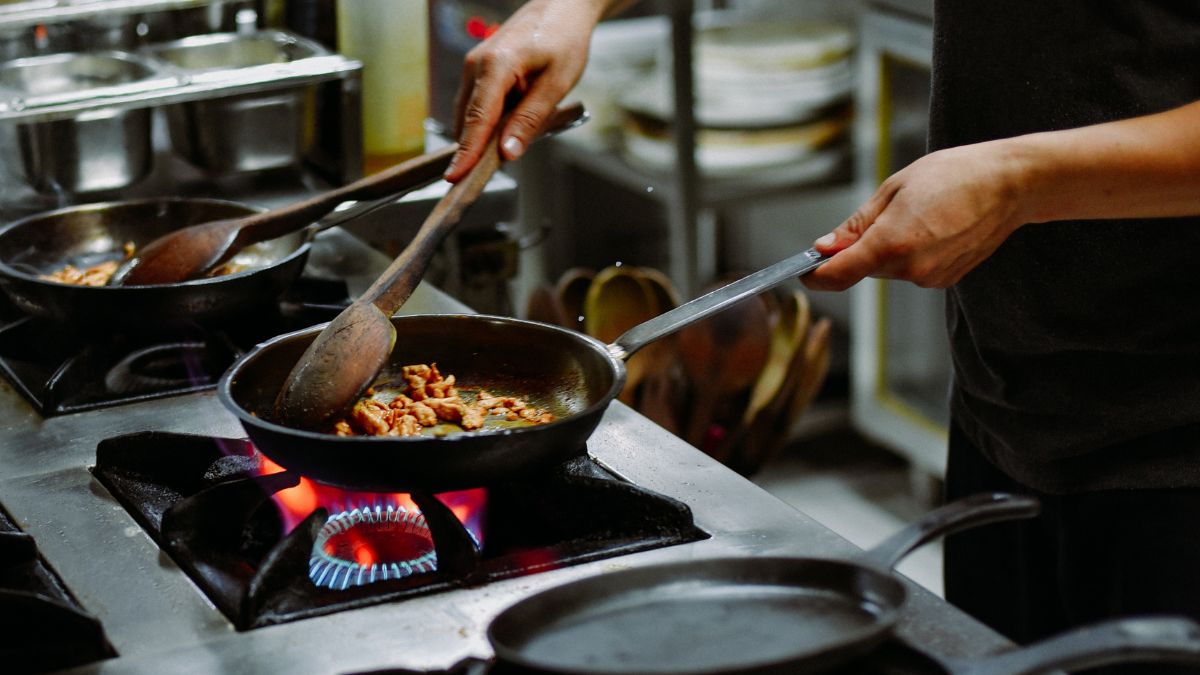 Foto de cozinheiro preparando pratos em uma empresa de grande porte em Paciência.