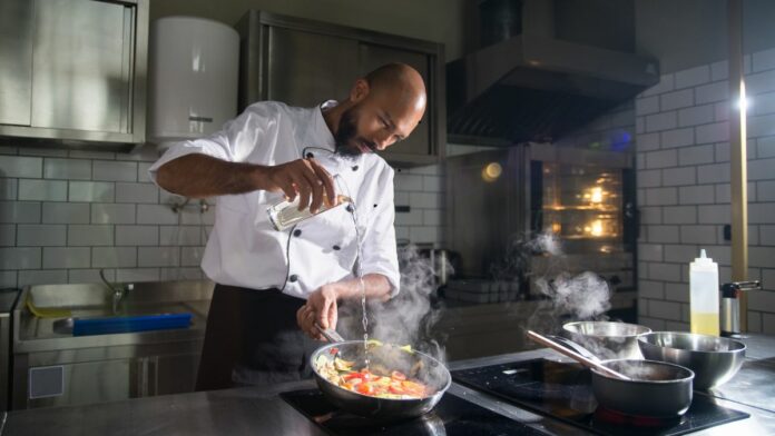 Auxiliar de Cozinha preparando alimentos em um Aeroporto do Rio, representando uma excelente oportunidade de emprego no setor de Refeições Coletivas